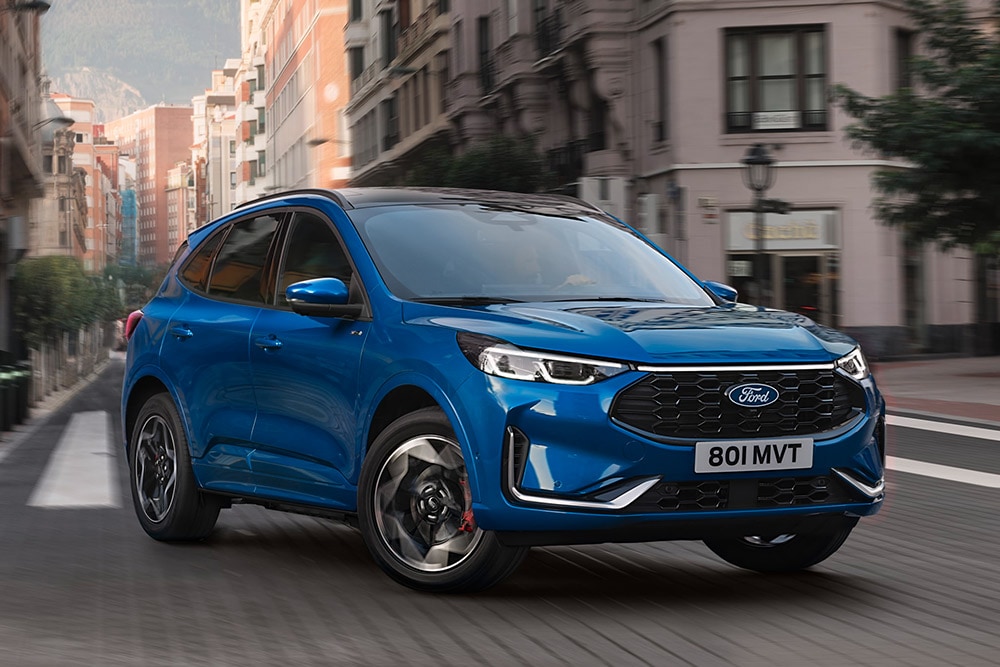 A blue Ford Kuga ST-Line driving through a city street