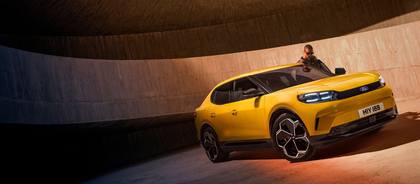 A new yellow Ford Capri® electric SUV parked in a car park.